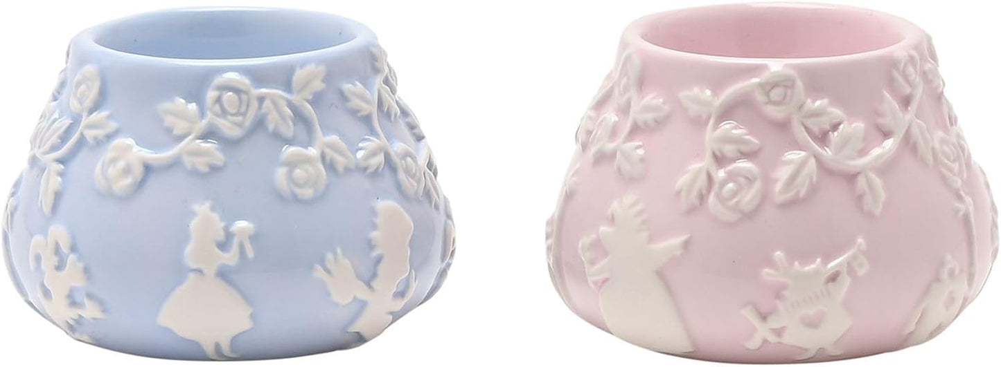 Two ceramic planters, one blue and one pink, with floral designs.