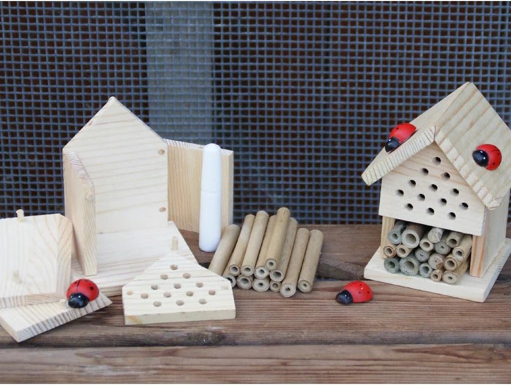 Wooden insect hotels and tubes on a wooden surface with a checkered background