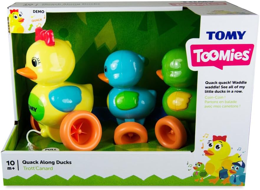 Tomy Toomies Quack Along Ducks toy set packaging with three colorful ducks on a green background.