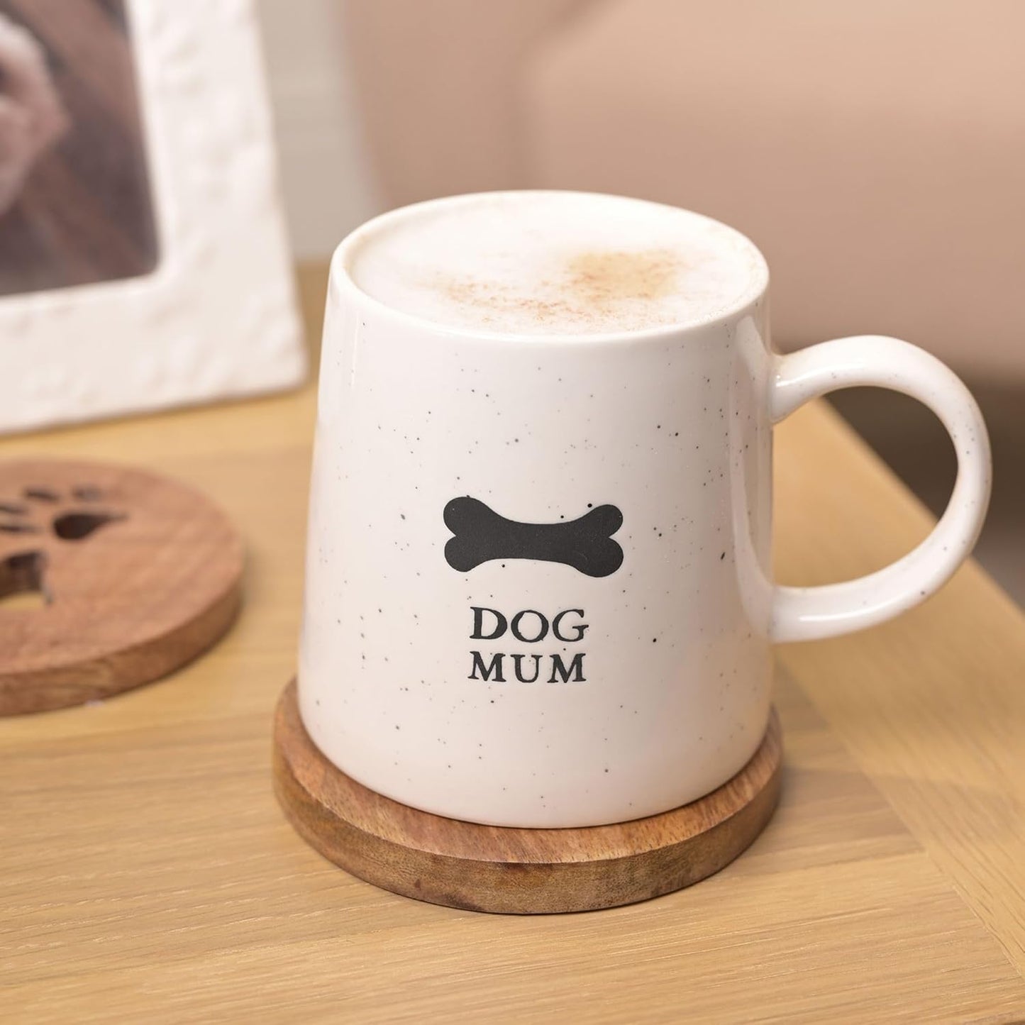 White mug with 'DOG MUM' text on a wooden coaster