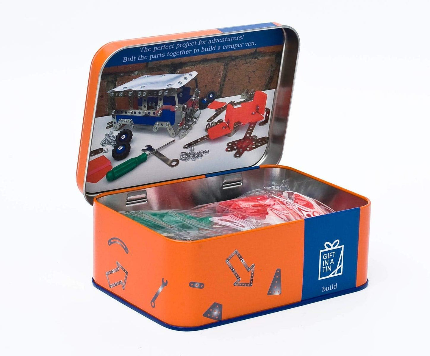 Toy construction set in an open tin box with tools and parts on a white background