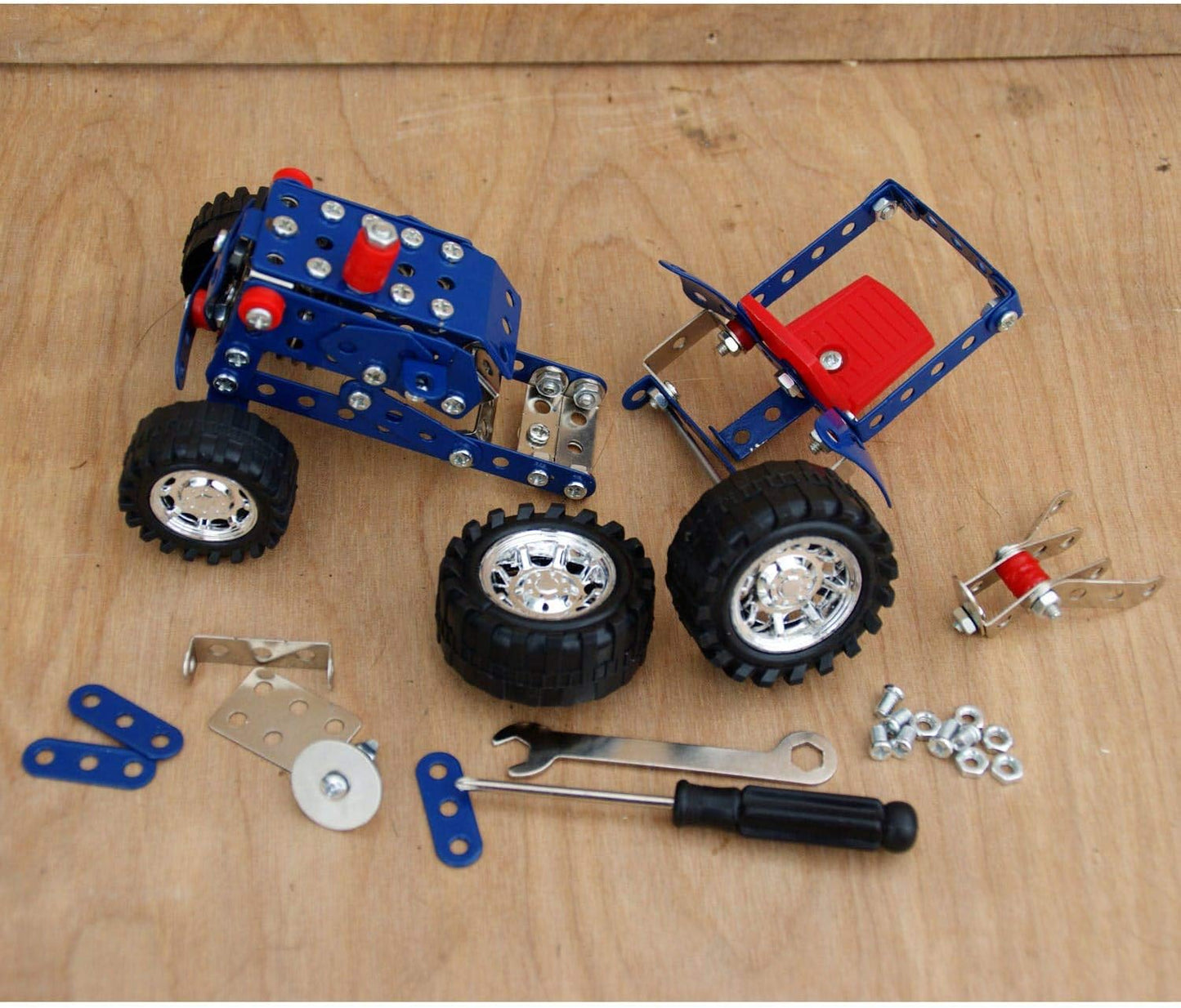 Toy Tractor set with wheels, tools, and parts on a wooden surface