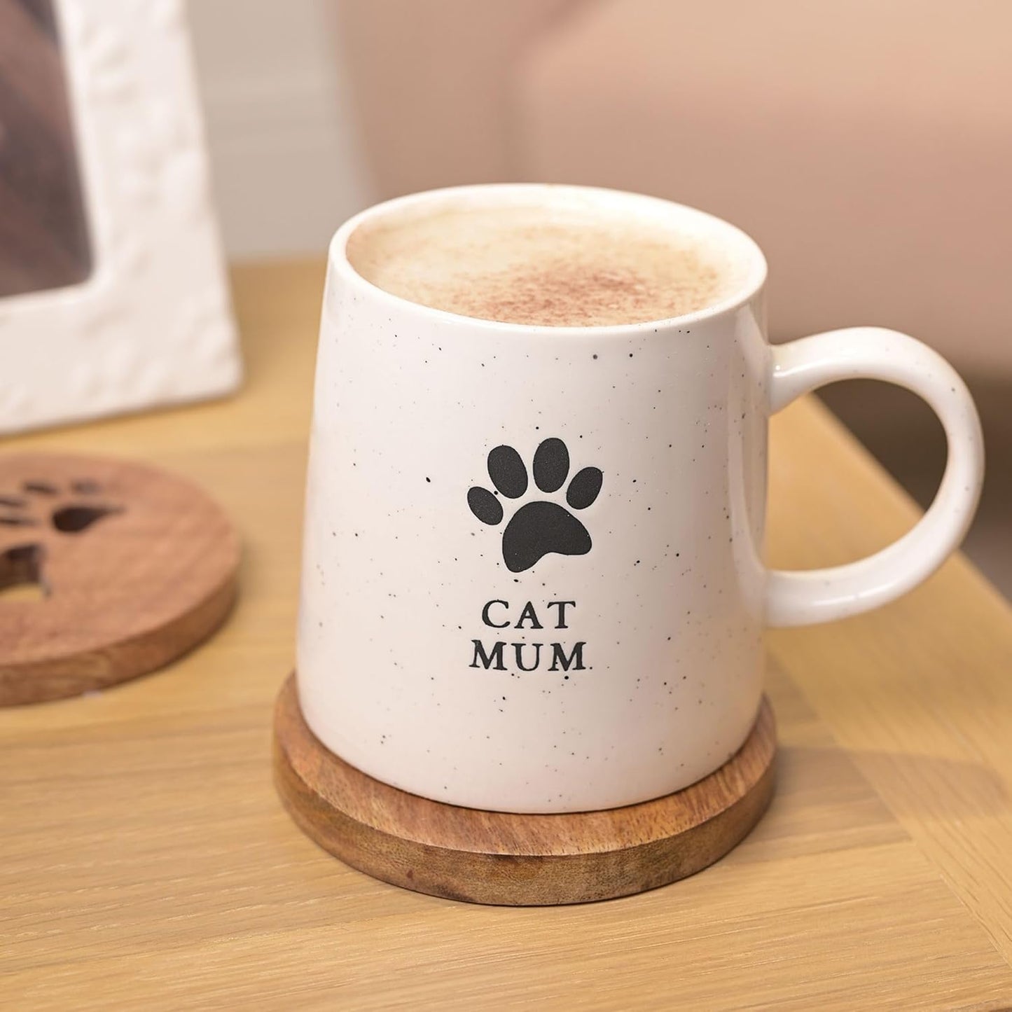 White mug with a paw print and 'Cat Mum' text on a wooden coaster