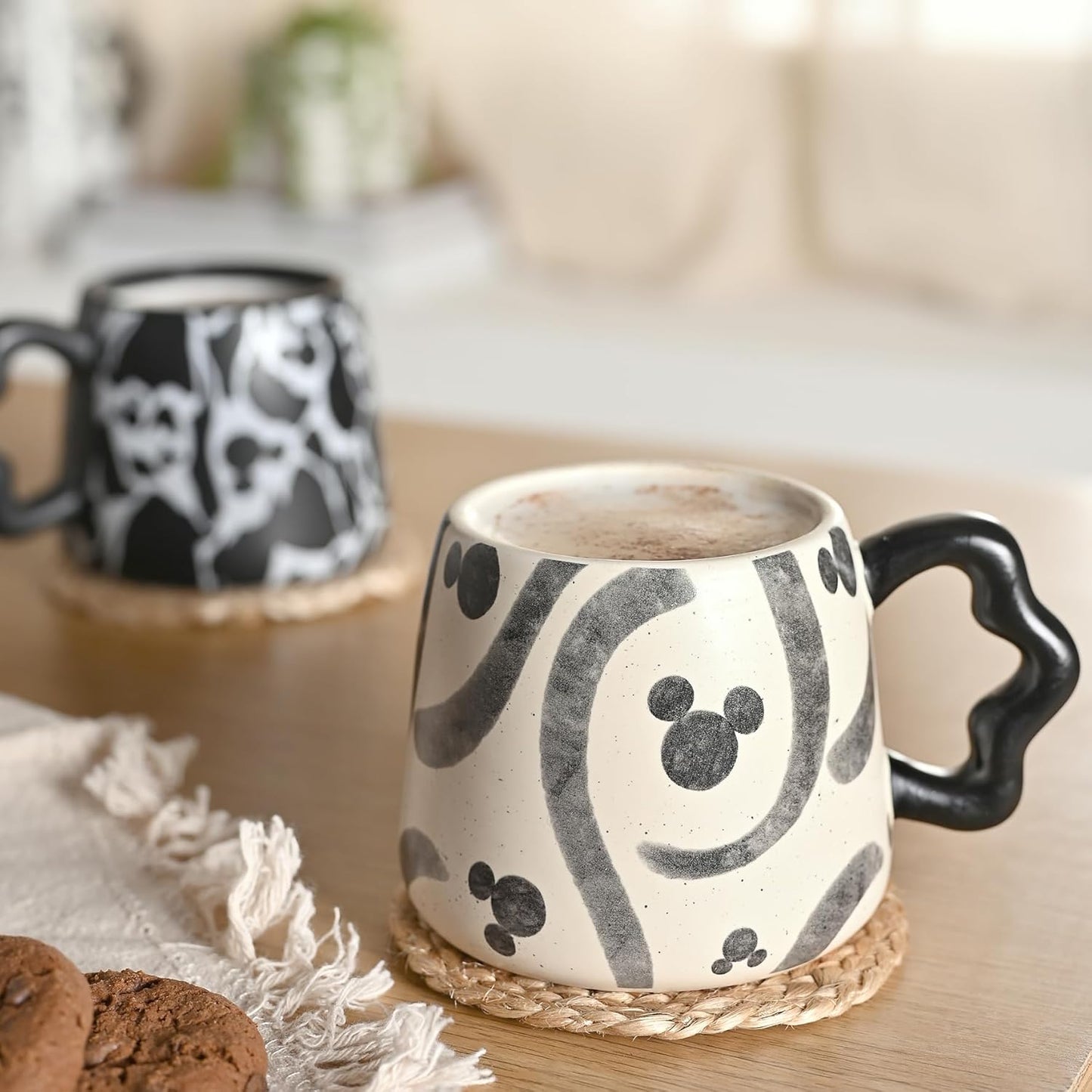Ceramic mugs with black abstract patterns on a wooden surface
