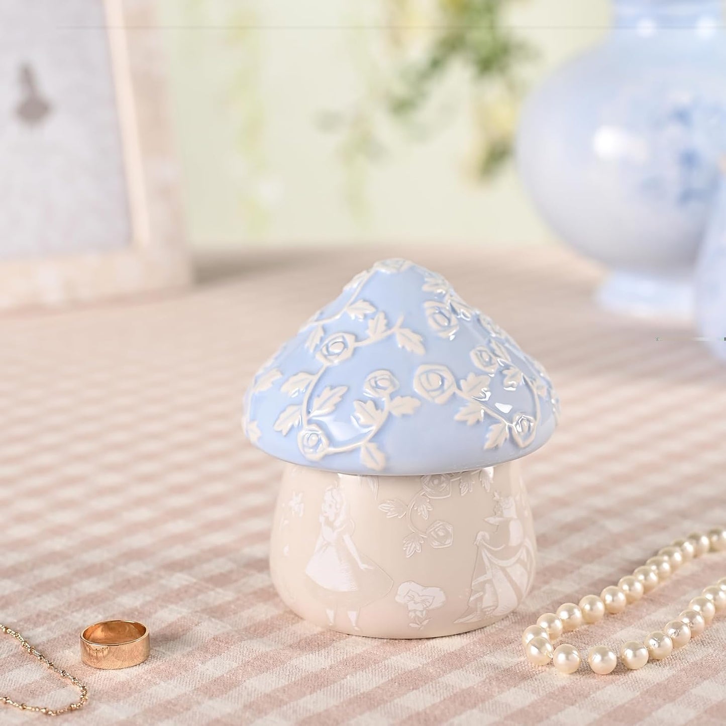 Decorative mushroom-shaped container with floral design on a textured surface.