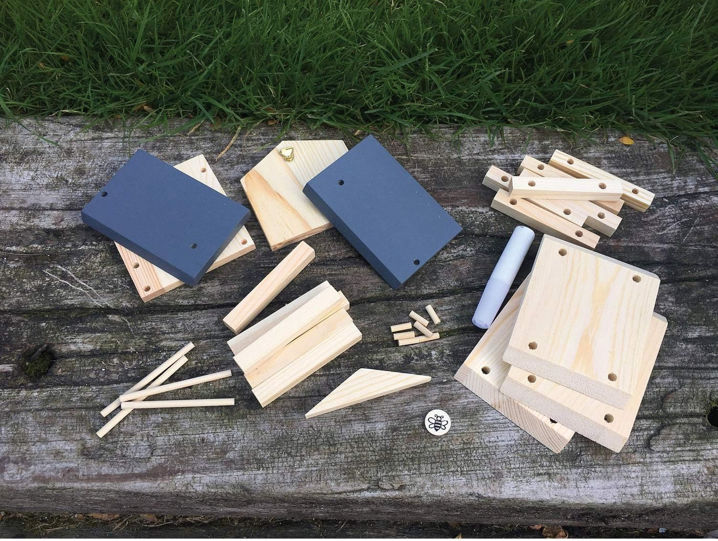 Wooden building blocks on a wooden surface with grass in the background