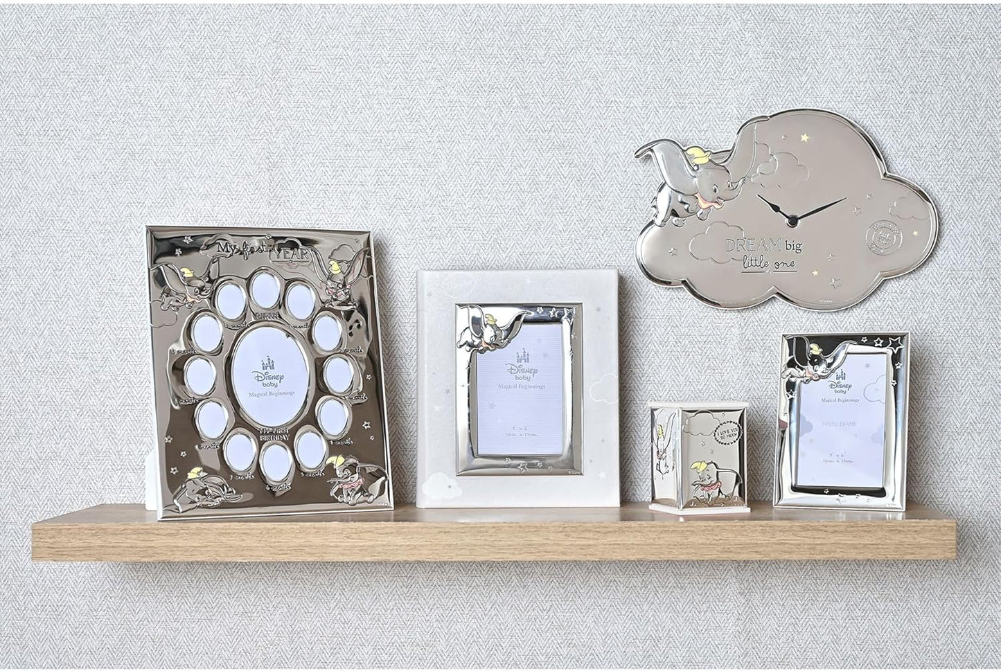Collection of silver photo frames on a wooden shelf against a light gray wall.