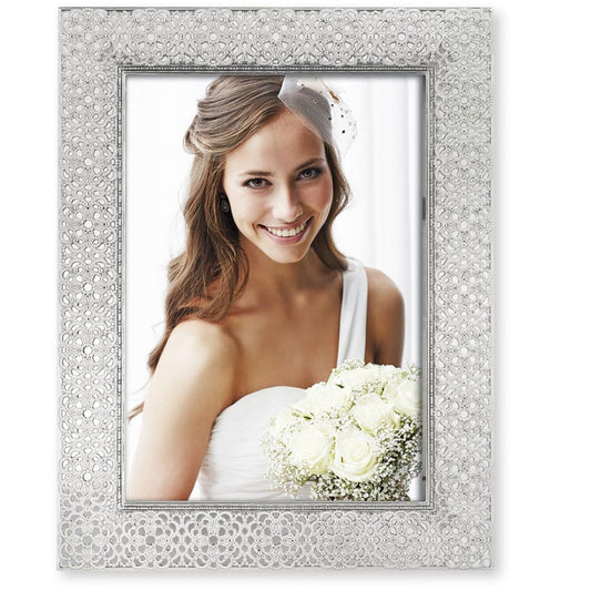 A silver photo frame with a floral design and a woman's portrait photo inserted. The frame has a see-through lace effect finish and solid borders.