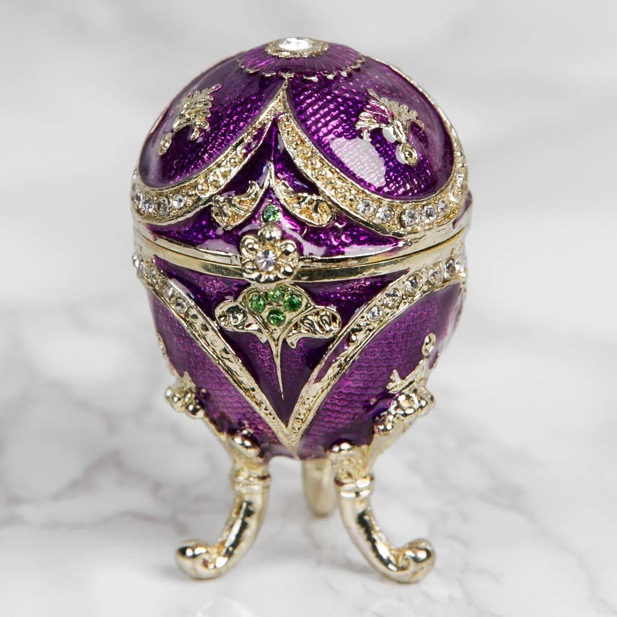 Decorative purple egg with gold accents on a white background