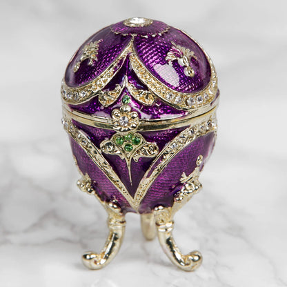 Decorative purple egg with gold accents on a white background