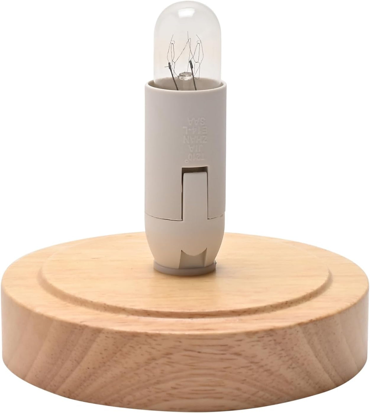 A miniature light bulb with a clear glass capsule and a beige plastic base, displayed on a round, light-colored wooden base against a white background.