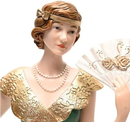 Decorative figurine of a woman in a gold dress and pearl necklace on a white background
