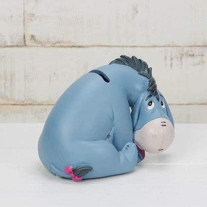 Eeyore Dumbo Money Box in front of brick wall side profile