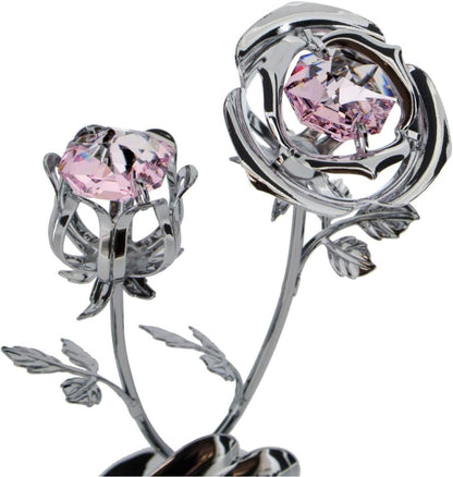 Silver flower-shaped object with pink gemstones on a white background