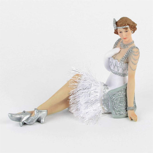 Figure sitting down with a white and silver dress