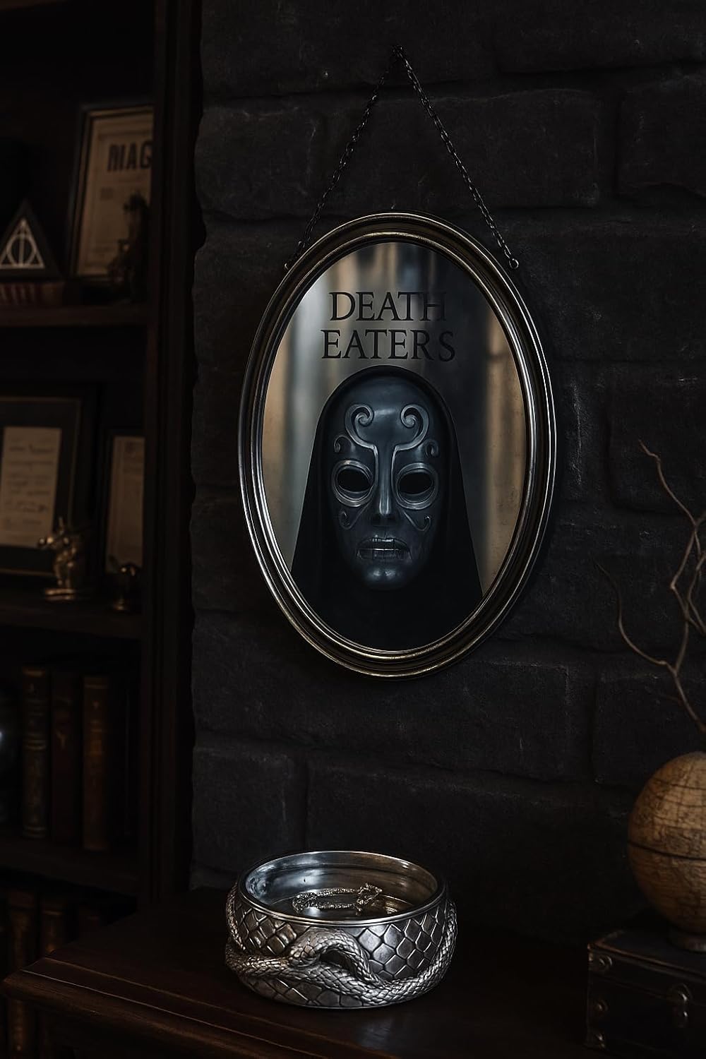 Oval mirror with 'Death Eaters' text and dark mask reflection on a stone wall.