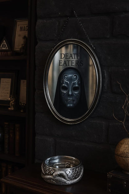 Oval mirror with 'Death Eaters' text and dark mask reflection on a stone wall.