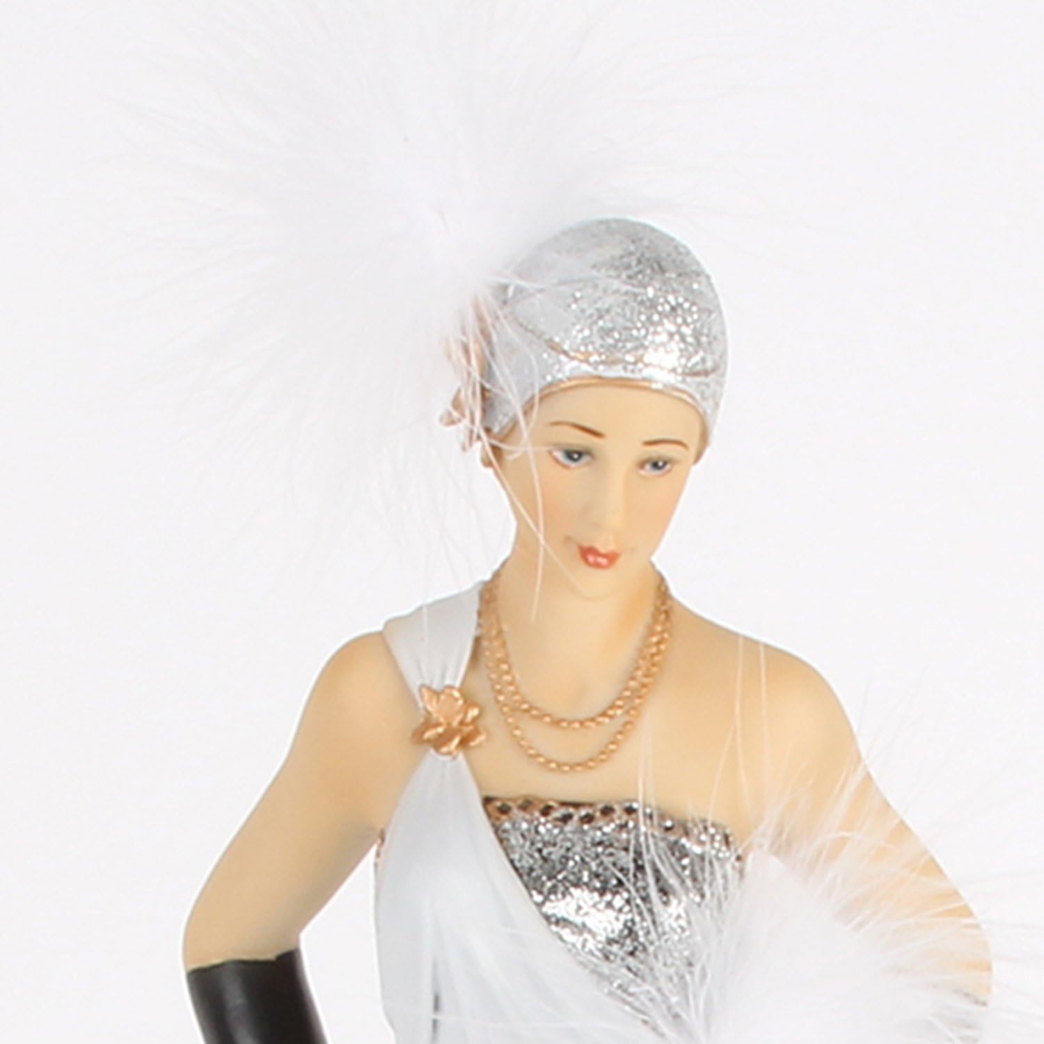 Mannequin wearing a silver head covering, white garment, and gold jewelry on a white background