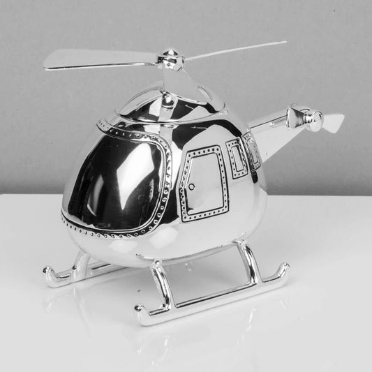 Silver helicopter model on a white surface with a gray background