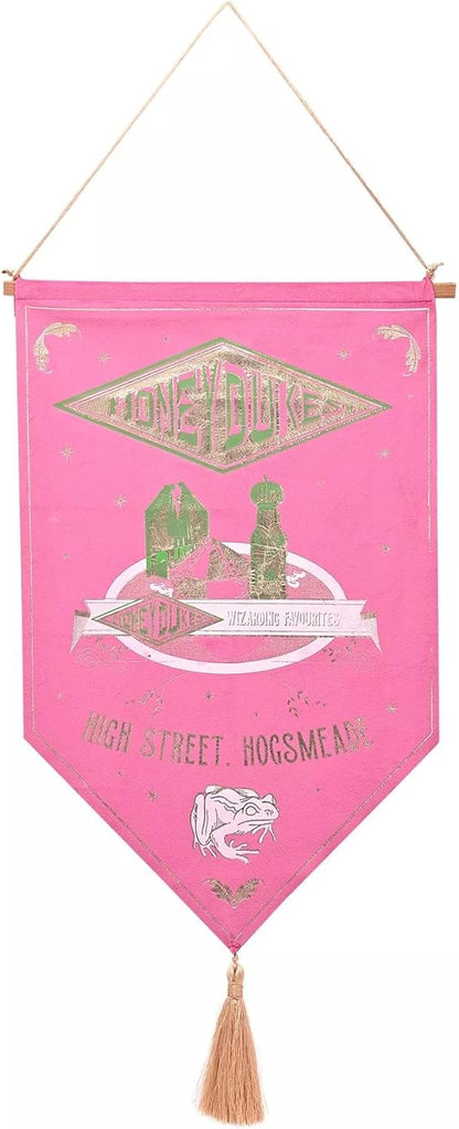A pink hanging pennant banner for 'High Street Hogsmeade' from Harry Potter  featuring Gold and white illustrations, a tassel at the bottom, and a hanging cord.