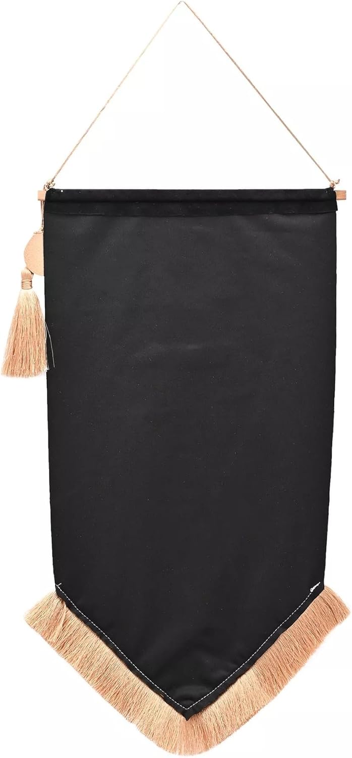 A black fabric wall banner with a pointed bottom, beige fringe trim, and a hanging cord with a tassel, shown against a plain white background.