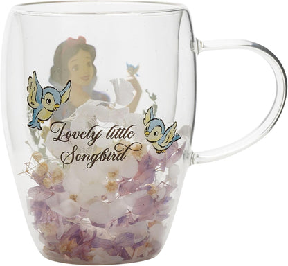 A clear glass double-walled mug featuring a printed design of Snow White with the text 'Lovely little Songbird' and bluebirds, filled with white and purple flowers inside.