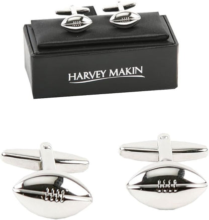 Silver Rugby-shaped cufflinks with a black box labeled 'Harvey Makin' on a white background.