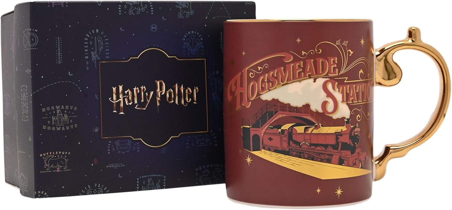 A Harry Potter Hogwarts Meade Station ceramic mug with a gold handle and trim, shown next to its dark blue presentation box featuring the Harry Potter logo.