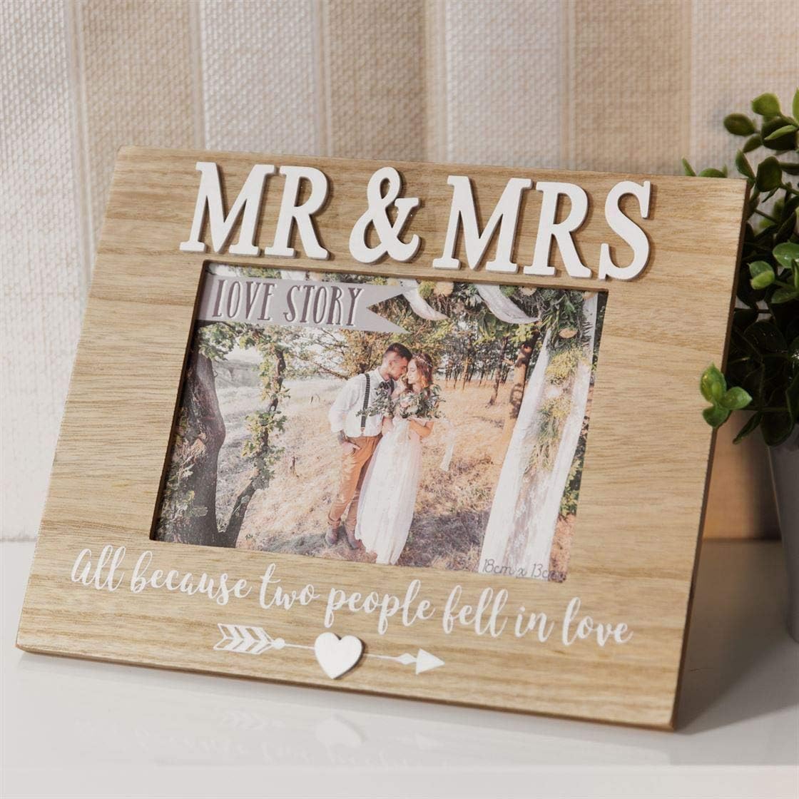 Wooden photo frame with 'MR & MRS' and a couple's picture inside, placed on a surface.