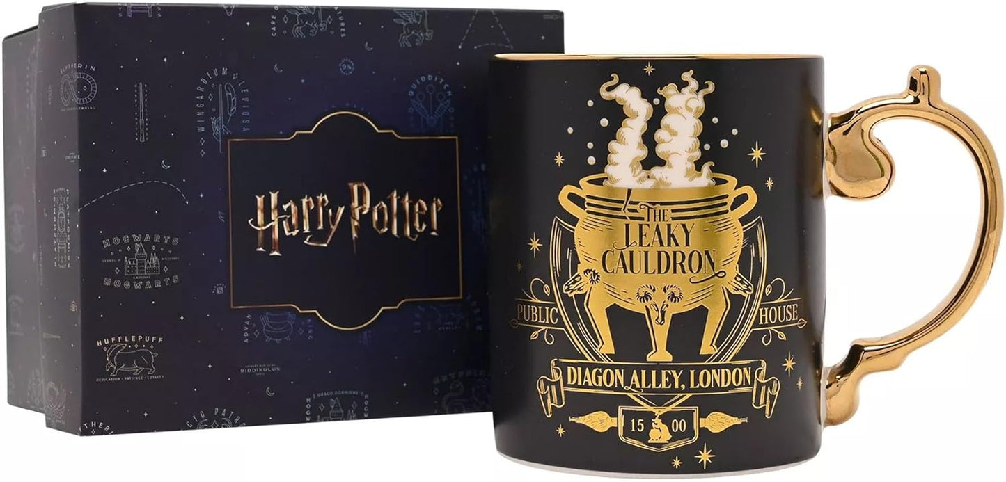 A black ceramic Harry Potter mug with a gold cauldron design and handle, shown next to its dark blue branded gift box.