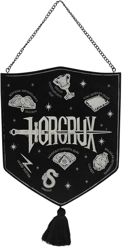 A black shield-shaped wall hanging banner with a silver-tone metal chain at the top and a black tassel at the bottom. The banner features white embroidered illustrations and text related to the fantasy band Horcrux, including the Horcrux logo, a dagger, an eye, and other magical symbols.