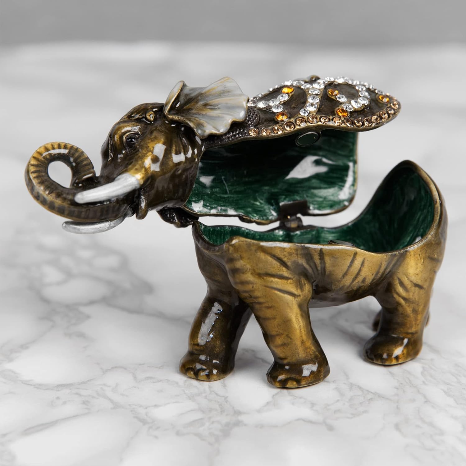 Decorative elephant figurine with jewelry on a marble surface