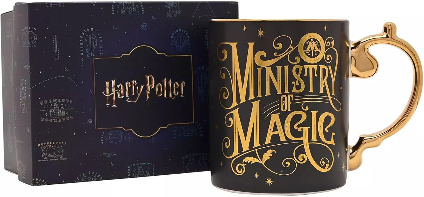 A black ceramic Harry Potter 'Ministry of Magic' mug with gold lettering and a gold handle, shown next to its dark blue branded gift box.