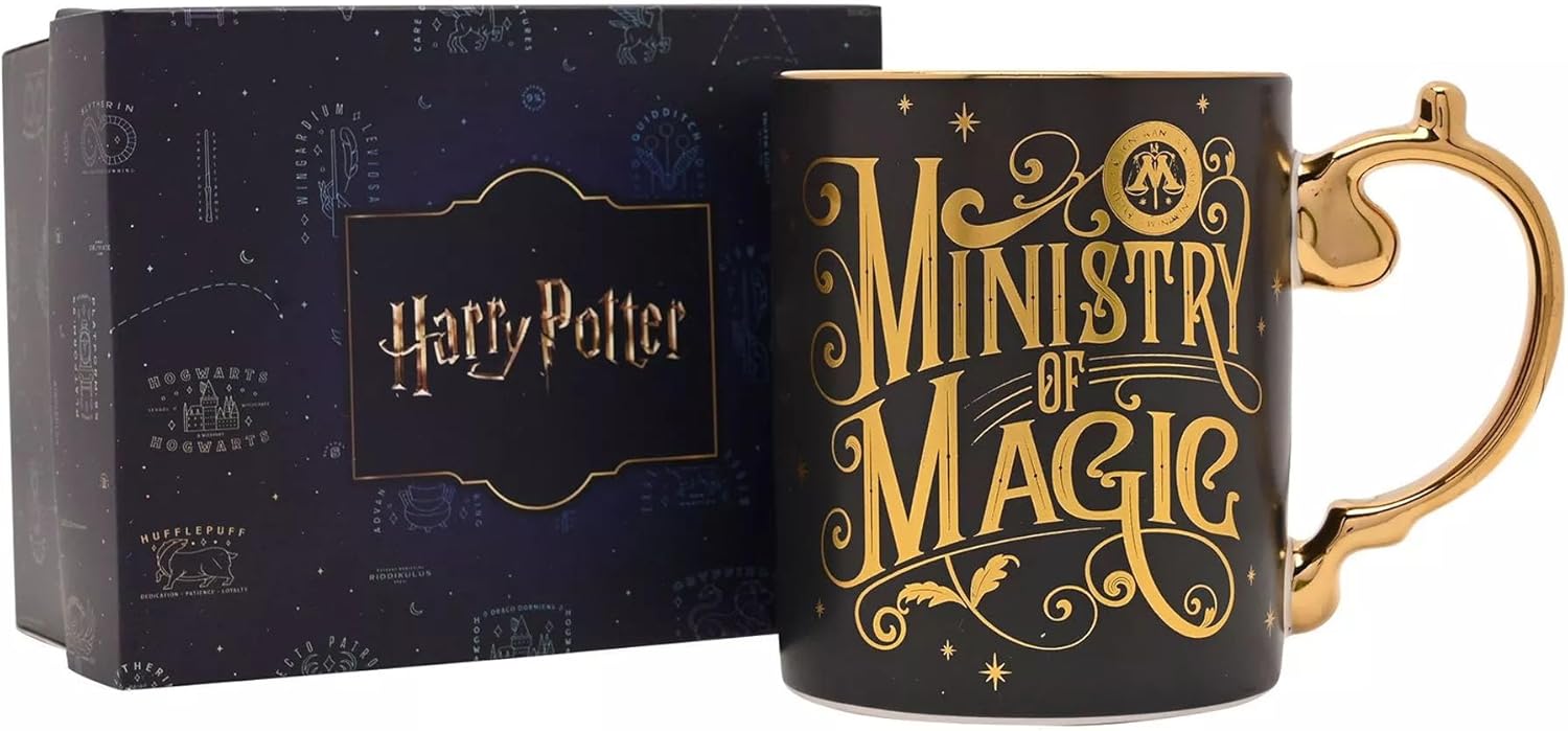 A black ceramic Harry Potter 'Ministry of Magic' mug with gold lettering and a gold handle, shown next to its dark blue branded gift box.