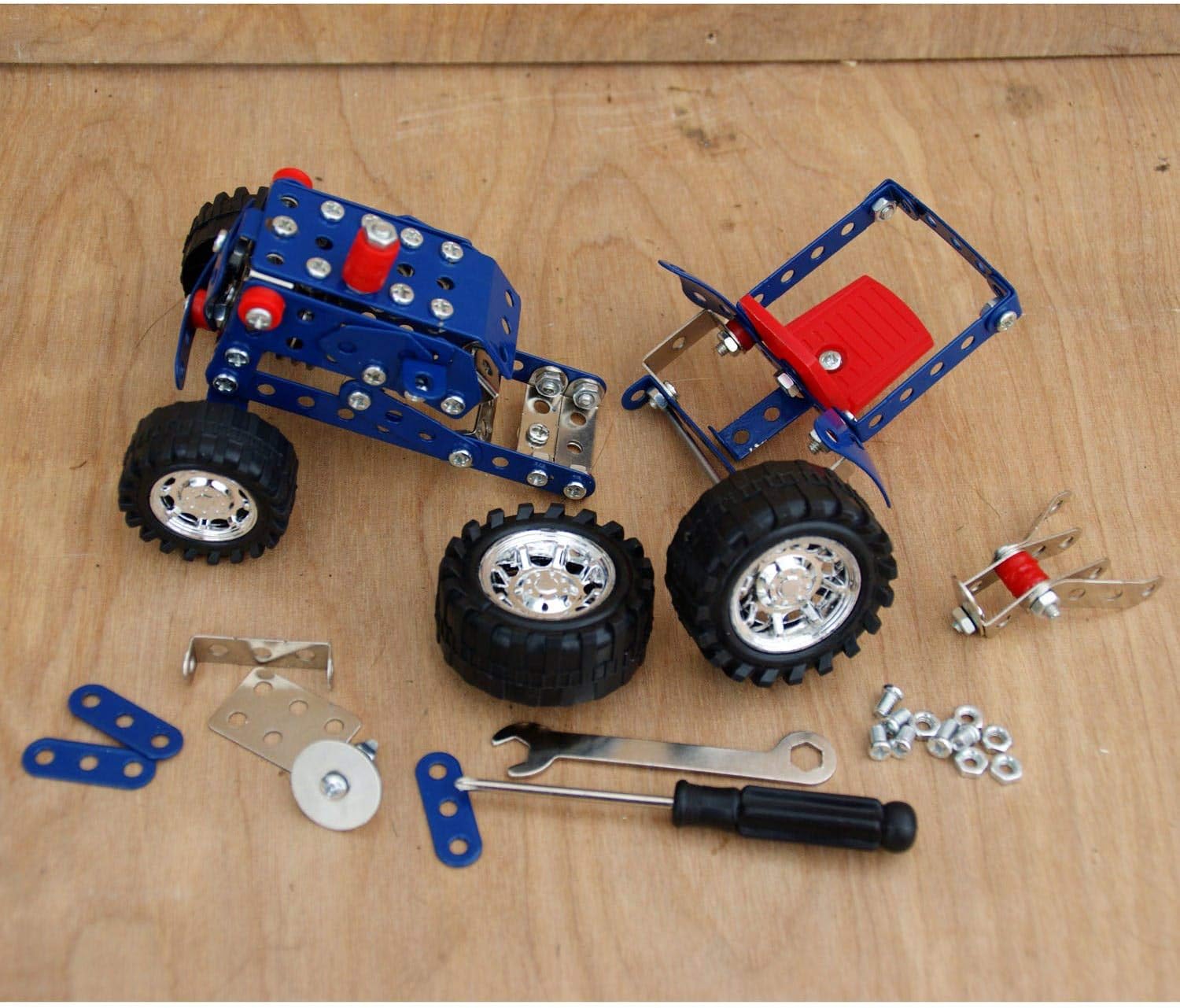 Toy Tractor set with wheels, tools, and parts on a wooden surface