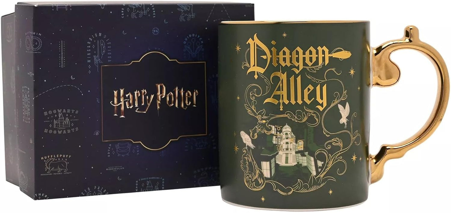 A dark green Harry Potter Diagon Alley ceramic mug with gold lettering and illustration, shown next to its dark blue branded gift box.