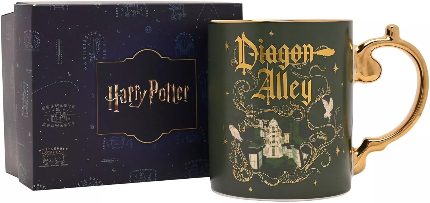 A dark green Harry Potter Diagon Alley ceramic mug with gold lettering and illustration, shown next to its dark blue branded gift box.