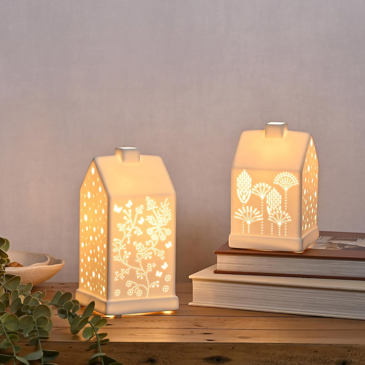 Two decorative lamps with floral patterns on a wooden surface.