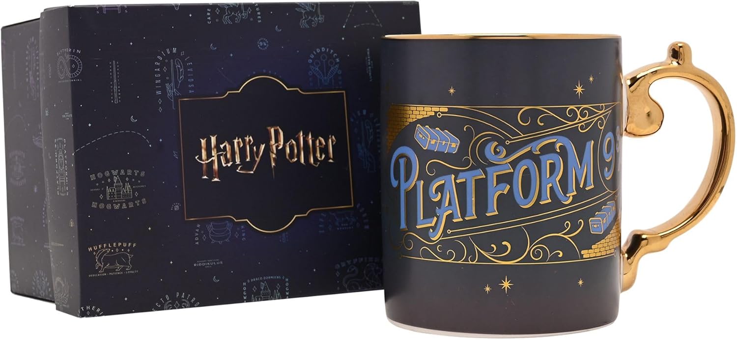 A dark navy blue Harry Potter Platform 9 3/4 mug with gold trim and a gold handle, shown next to its branded dark blue gift box.