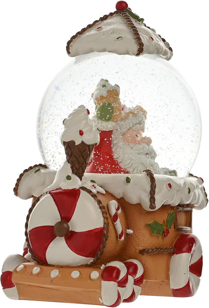 A Christmas-themed snow globe figurine featuring Santa Claus and a gingerbread train decorated with candy canes, white icing details, and red and green holiday accents, shown on a plain white background.