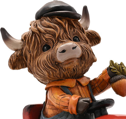 A decorative figurine of a shaggy Highland cow dressed as a farmer, wearing a black cap, orange plaid shirt, and suspenders, holding an acorn on a red vehicle against a white background.