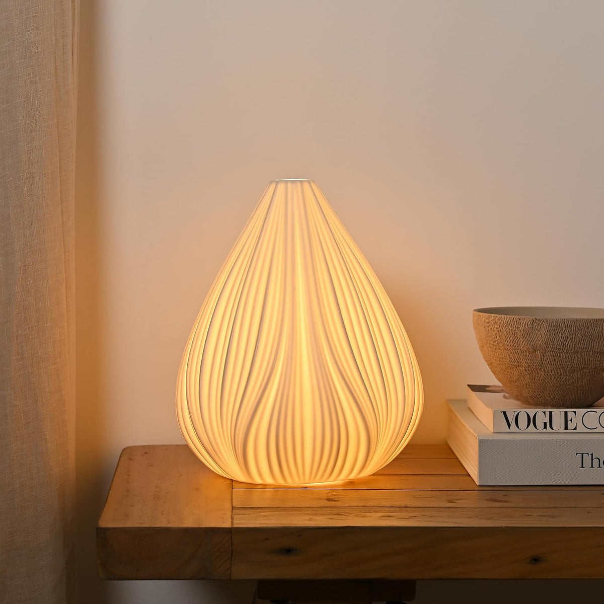 Decorative table lamp with wavy design on a wooden surface, emitting warm light.