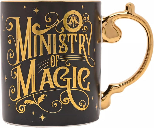 A black ceramic mug with a metallic gold handle and 'Ministry of Magic' text printed in gold on the side, shown against a plain white background.