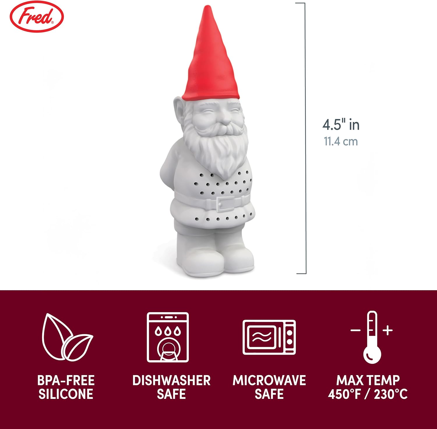 Tea infuser shaped like a gnome in a glass of tea on a wooden table with plants in the background.