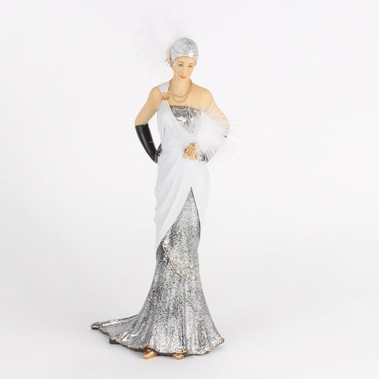 Figurine of a woman in a silver and white evening gown with gloves and a fan on a white background