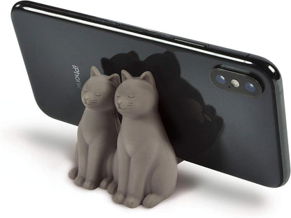 Phone holder shaped like two cats with a smartphone on a white background