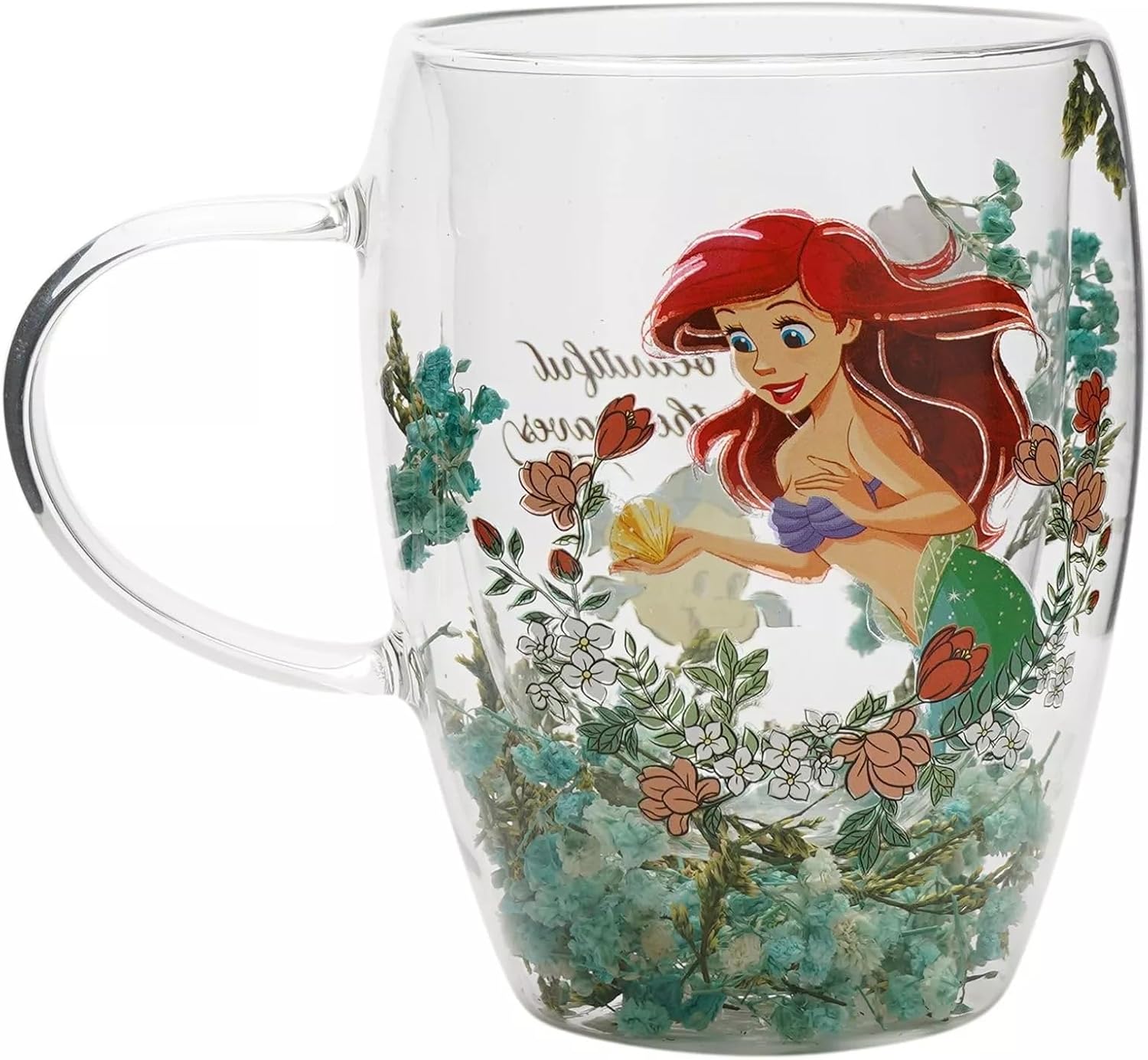 A clear glass double-walled mug featuring a colorful illustration of Disney's The Little Mermaid, Ariel, surrounded by underwater flowers and sea plants.