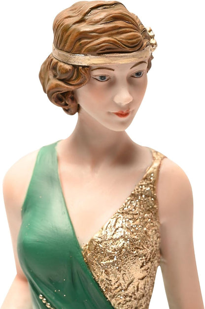 Statue of a woman in a green and gold dress with a decorative headpiece on a white background