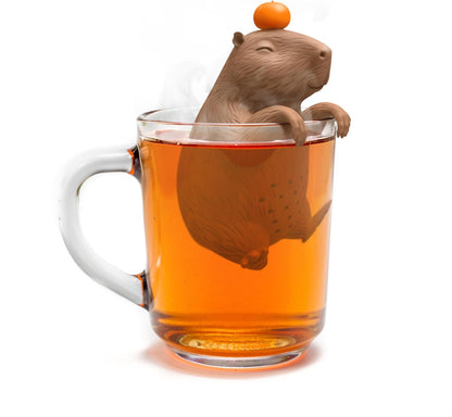 Tea infuser shaped like a beaver in a glass of tea on a white background