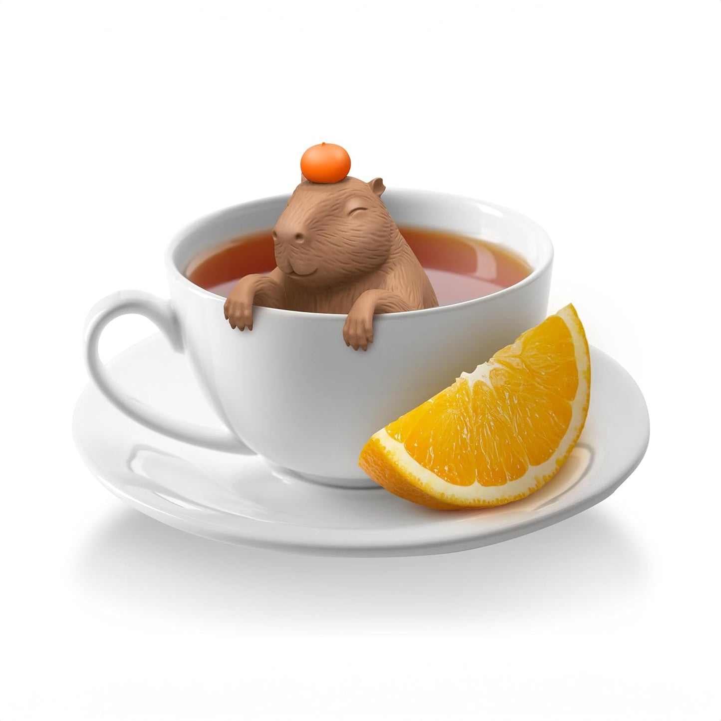 Tea cup with a small animal figure and an orange slice on a white background
